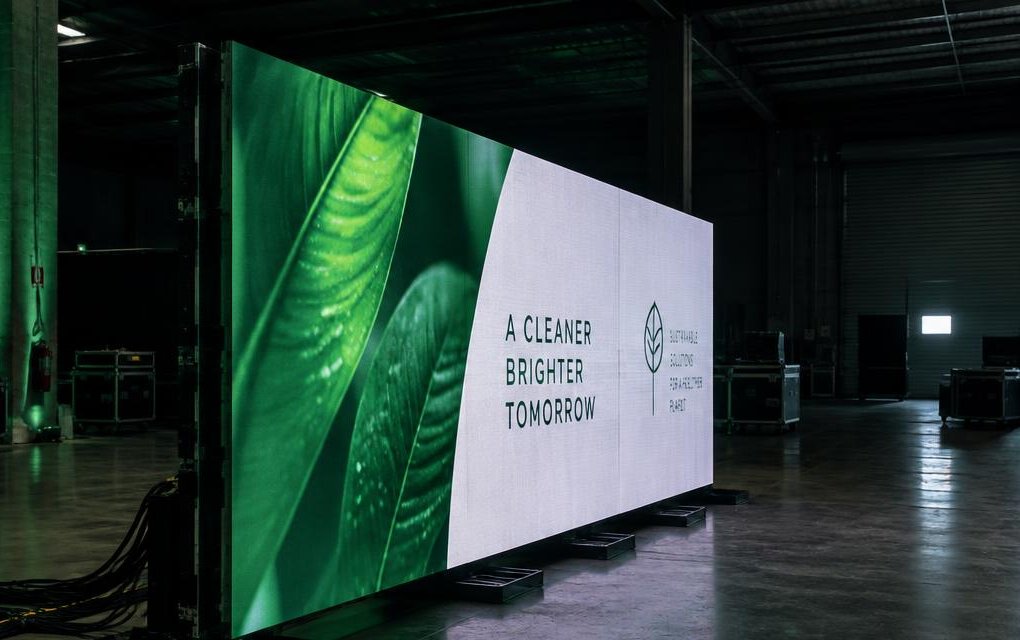 Ground-stacked LED video wall standing on weighted steel bases on a concrete floor